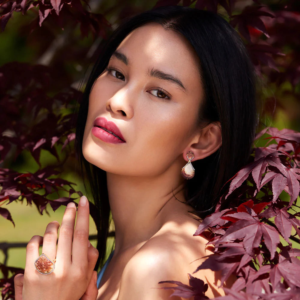 Woman wearing orange shell earrings