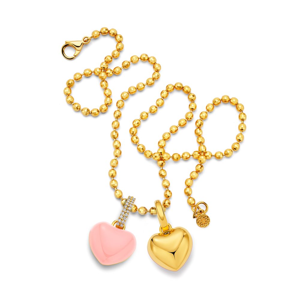 Two pink and gold heart charms on a gold chain with Buddha Mama's Puffy Heart Pendant in sky blue enamel.