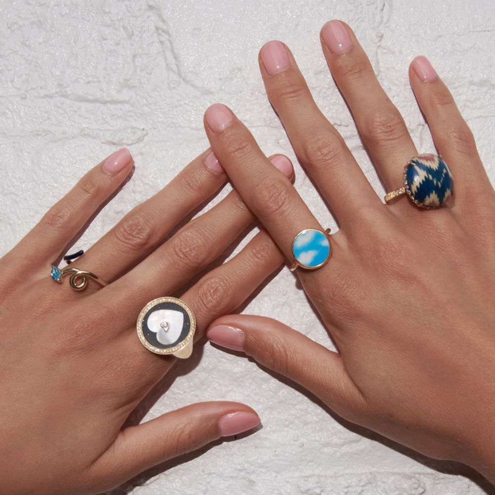 A woman's hands showcasing a stunning circle Silvia Furmanovich Blue Ikat Ring, complemented by a luxurious gold ring.