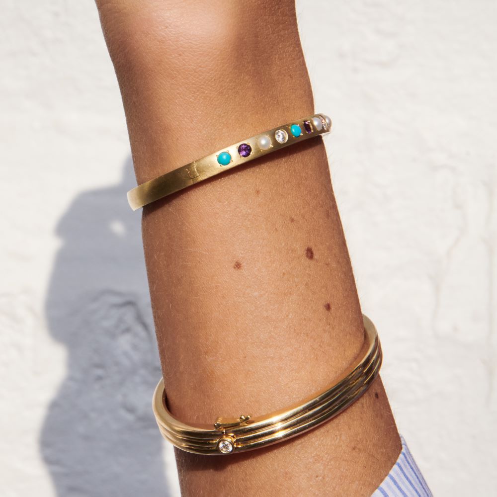 A woman wearing a Beck Scuba Trio Bangle cuff bracelet with white diamond stones.