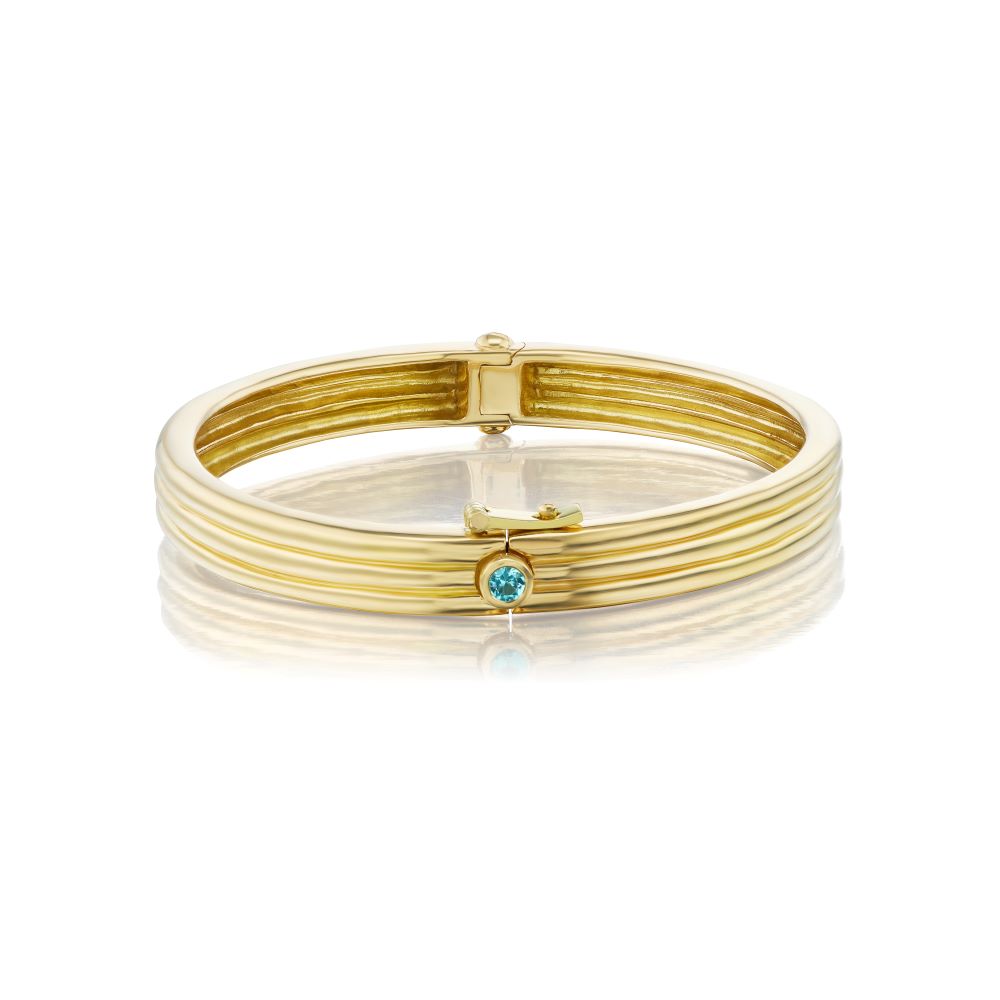 A Beck Scuba Trio Bangle adorned with a captivating blue topaz stone.