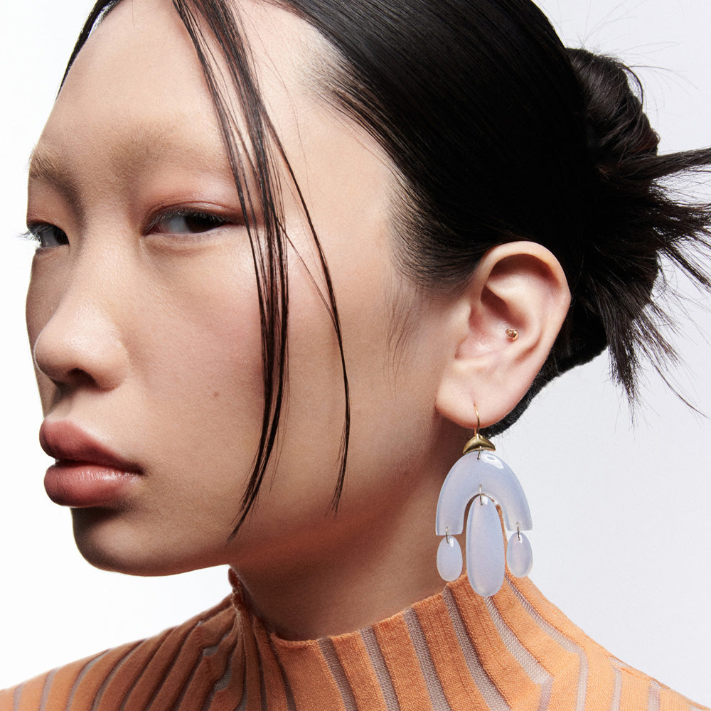 An Asian woman wearing a pair of Ten Thousand Things Chandelier Earrings.