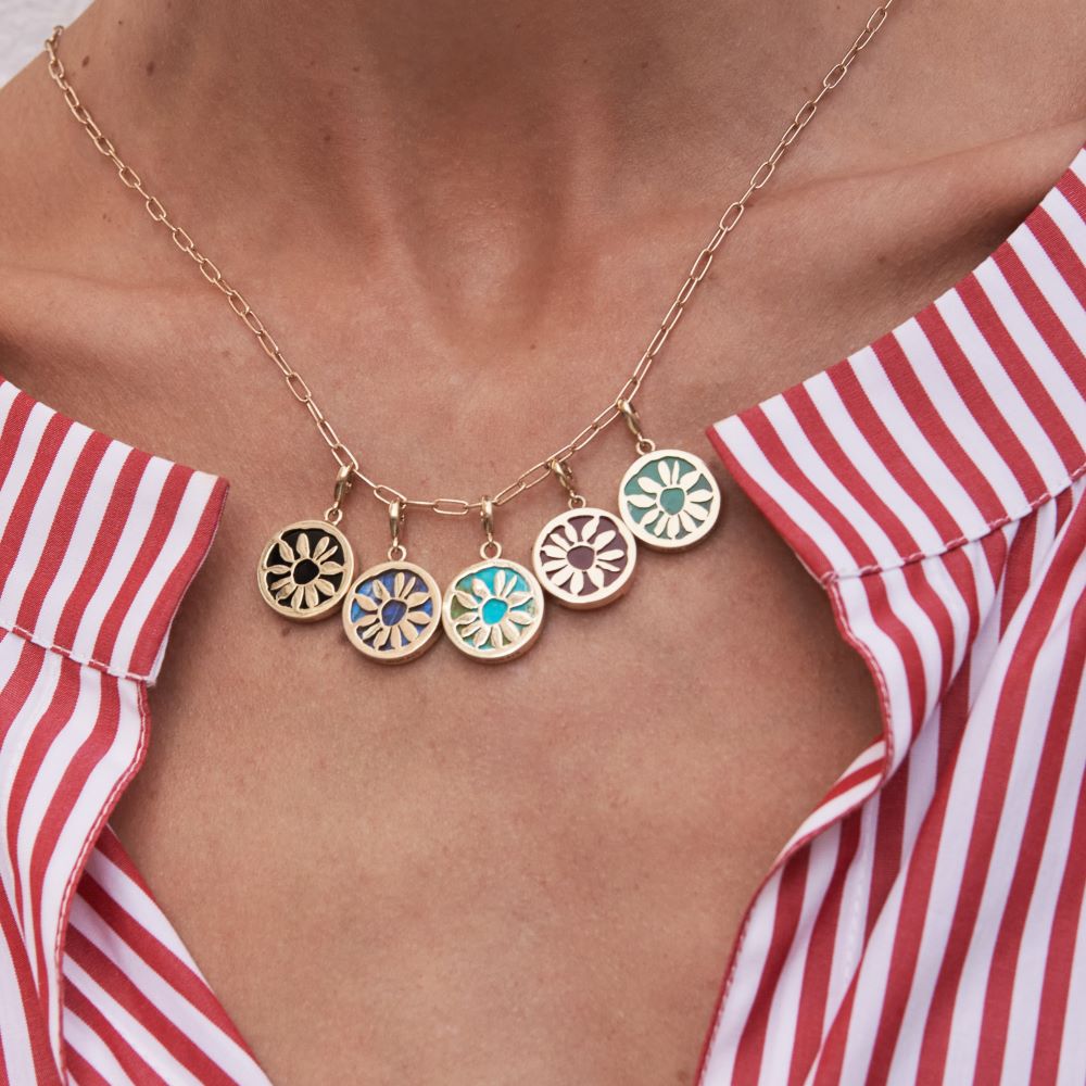 A woman wearing a red and white striped shirt and a necklace with a Luis Morais Flower Medallion Charm.