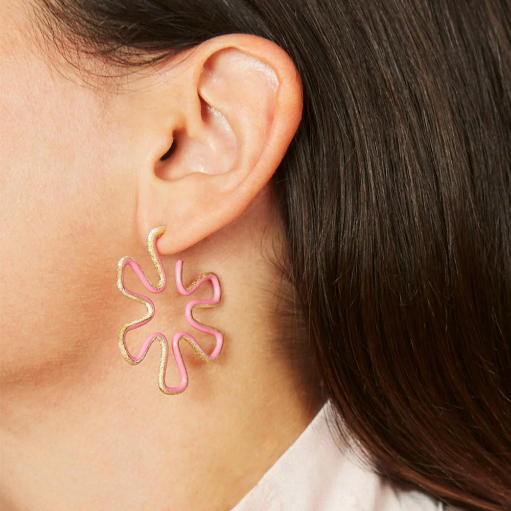 A woman wearing a playful, Bea Bongiasca Brushed Diamond Flower Hoop Earring.