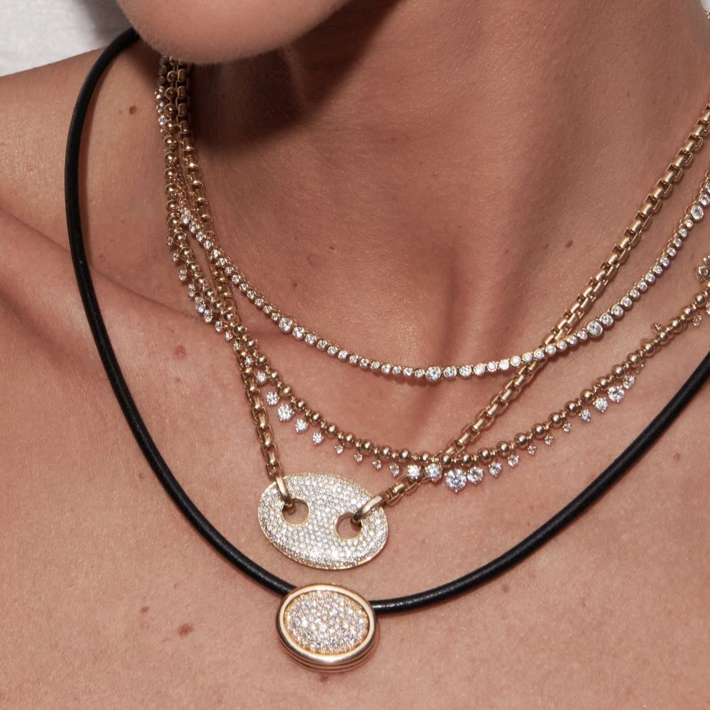 A woman is wearing Jenna Blake's Diamond Pavè Nautical Link Necklace with yellow gold and white diamonds.