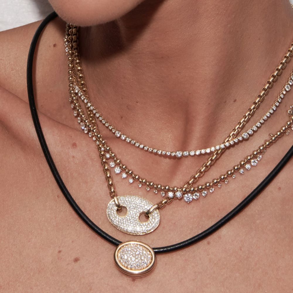 A woman is wearing an Ondyn Rainsun Necklace adorned with diamonds.