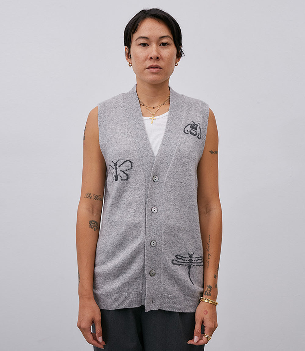 A woman wearing a No. 58 Grey Vest from Leret Leret with embroidered dragonflies on it, made from Mongolian cashmere.