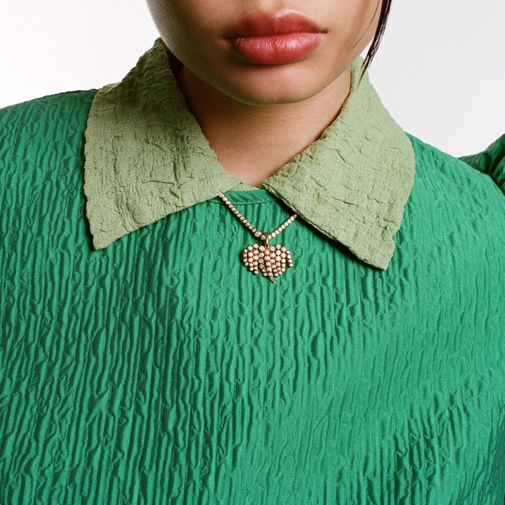 A woman wearing a green dress with an Ondyn Diamond Fringe Charm necklace.