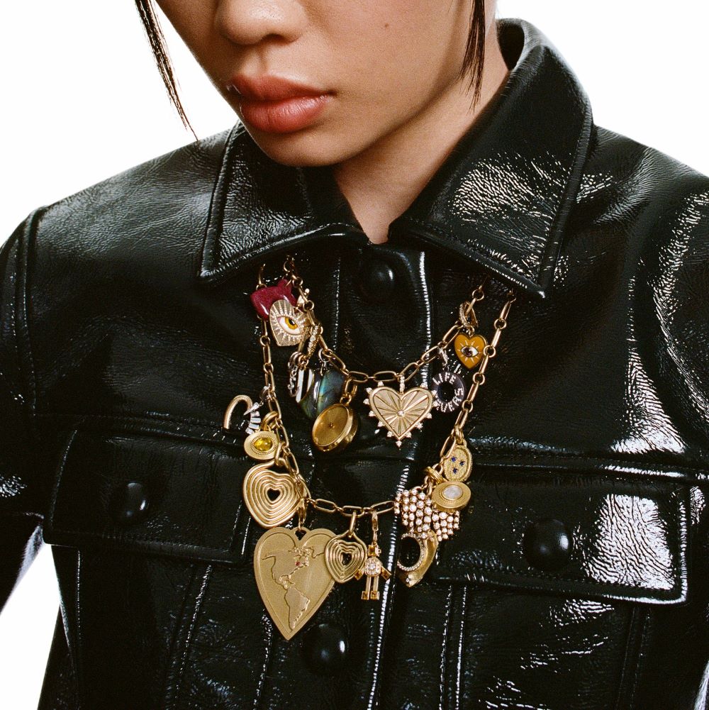A woman wearing a leather jacket with a Prounis Granulated Heart Charm necklace.