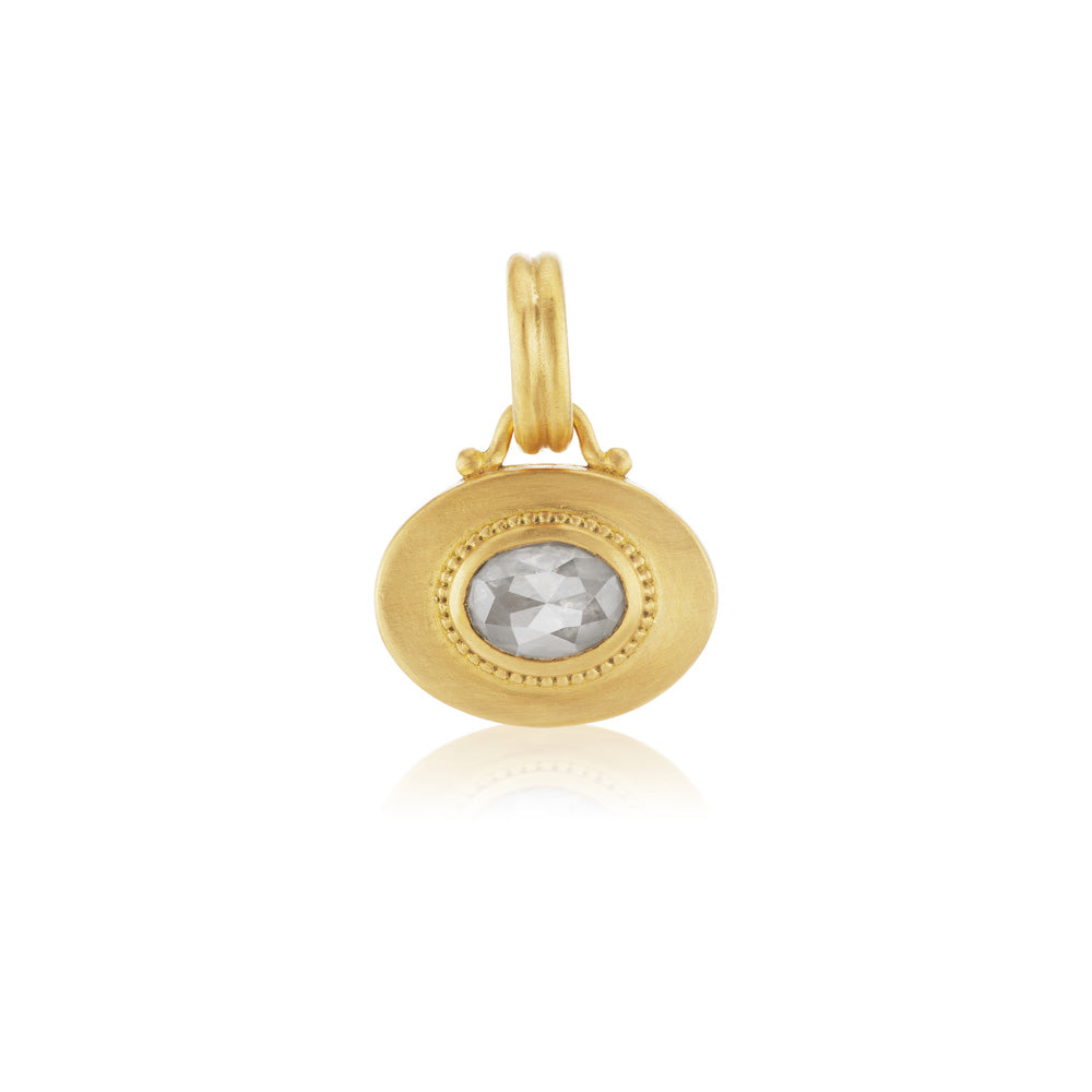 A yellow gold locket with a Granulated Heart Charm and Prounis sapphire charm.