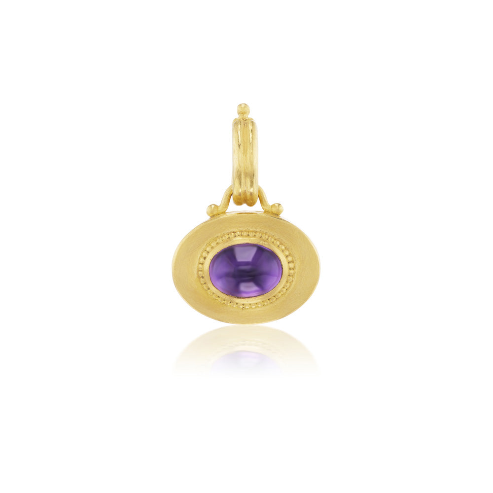 The Granulated Heart Charm pendant by Prounis showcases a vibrant purple stone.