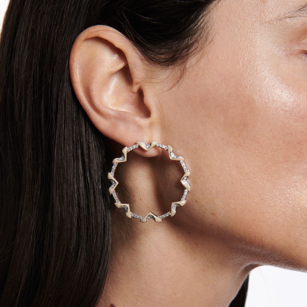 A woman wearing a pair of Matturi Taupe Circle Hoop Earrings.