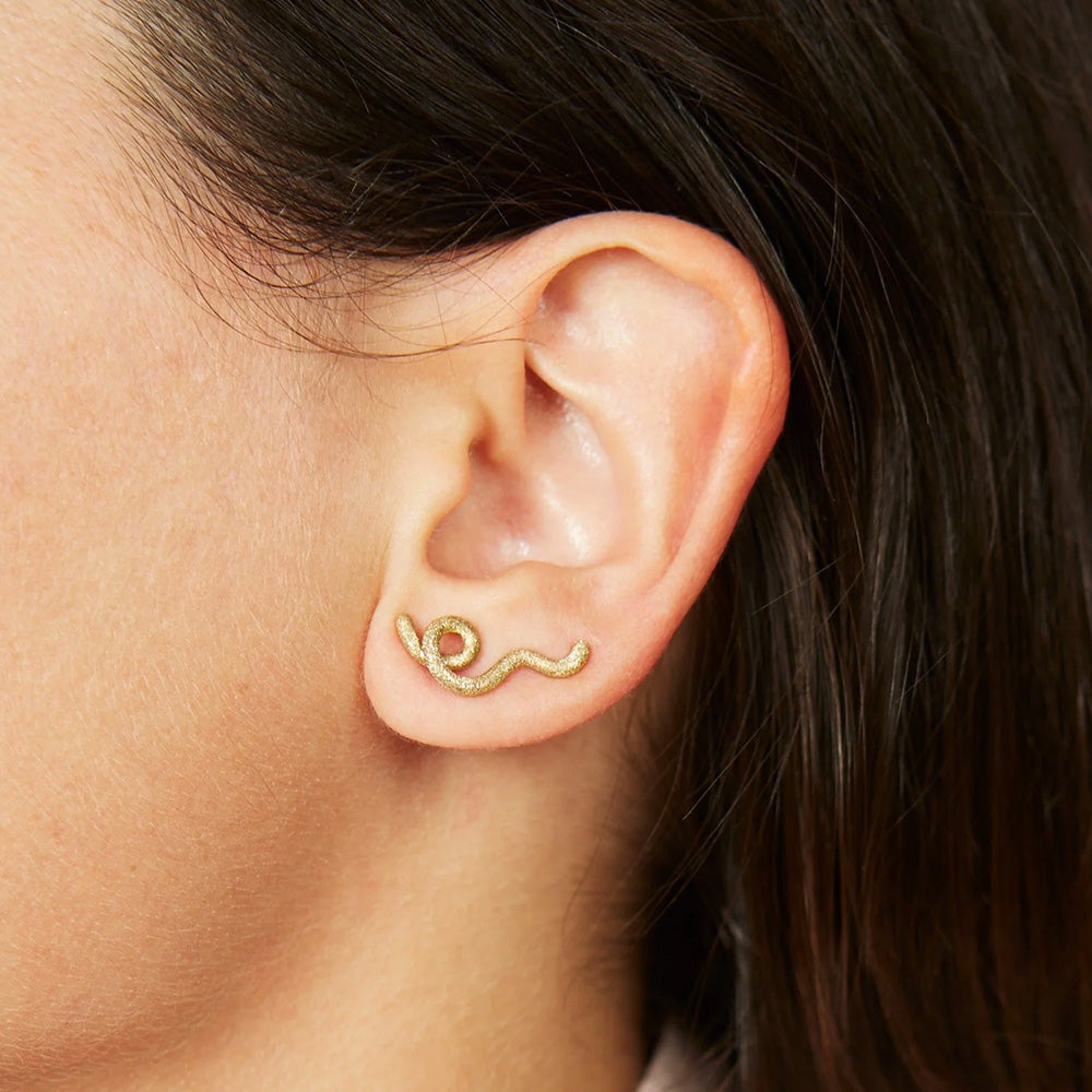 A woman wearing a pair of Bea Bongiasca Short Wave Earring lobe climber earrings with a diamond finish.
