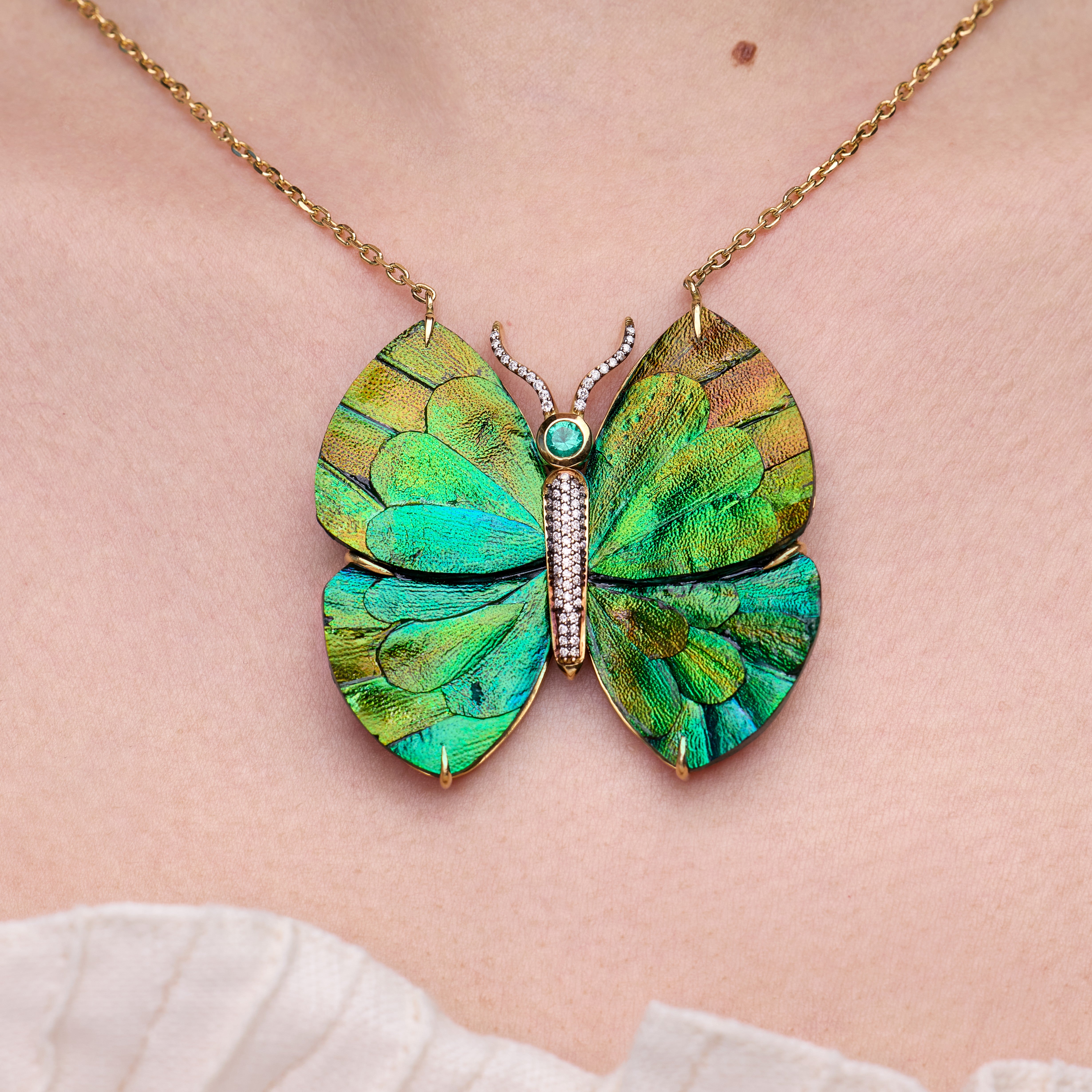 Wood butterfly necklace with beetle wing application and emerald in yellow gold
