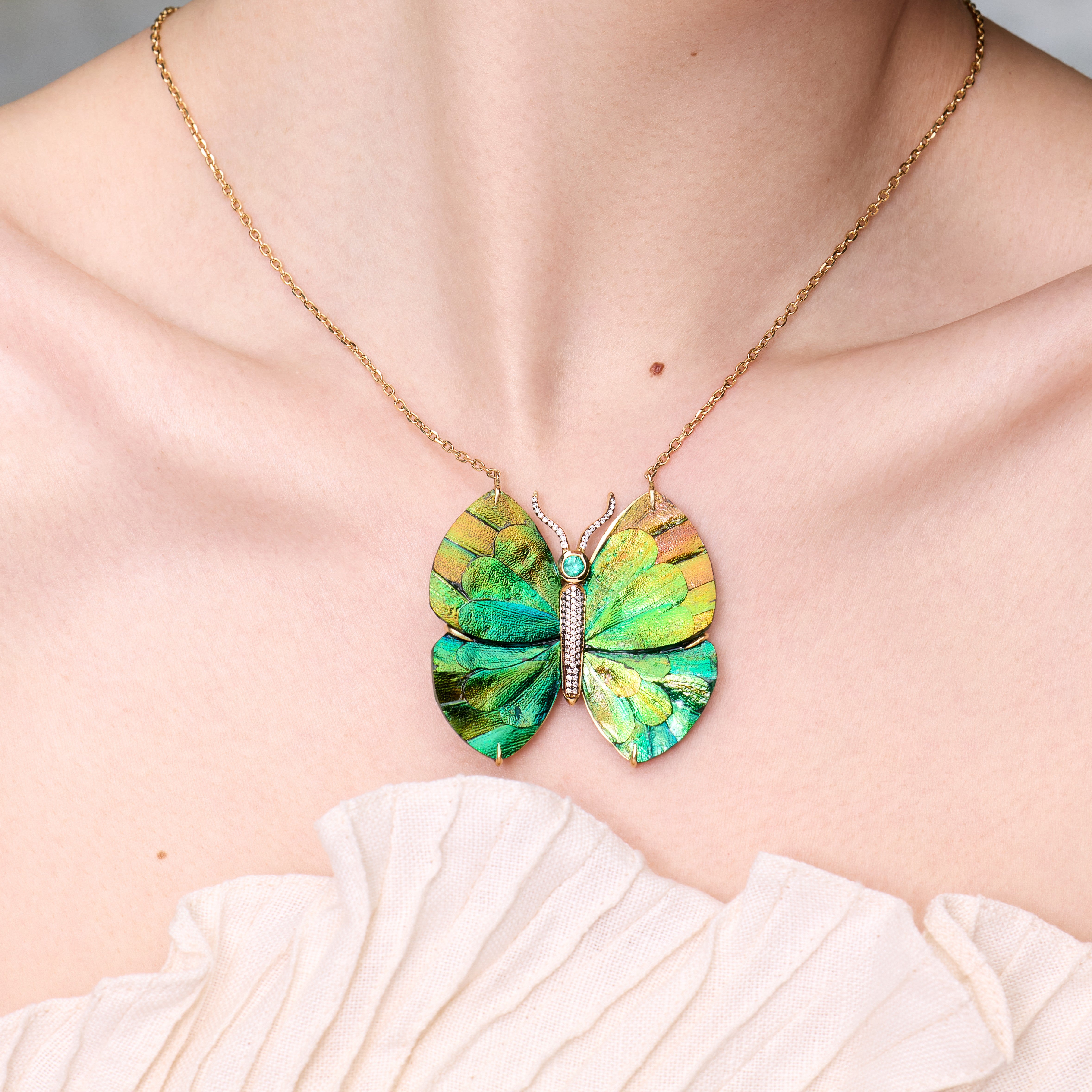 Wood butterfly necklace with beetle wing application and emerald in yellow gold