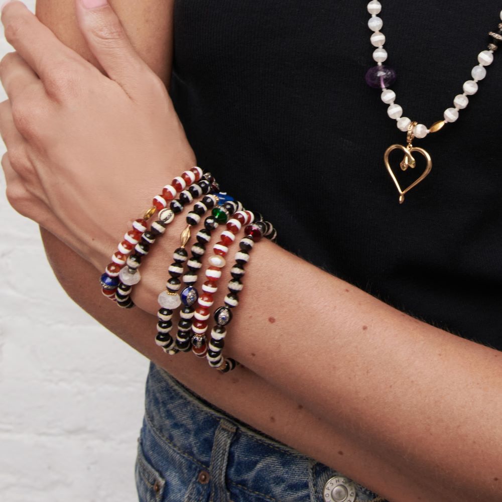 A woman wearing a Red Agate Beaded Bracelet adorned with Tibetan agate by Ileana Makari.