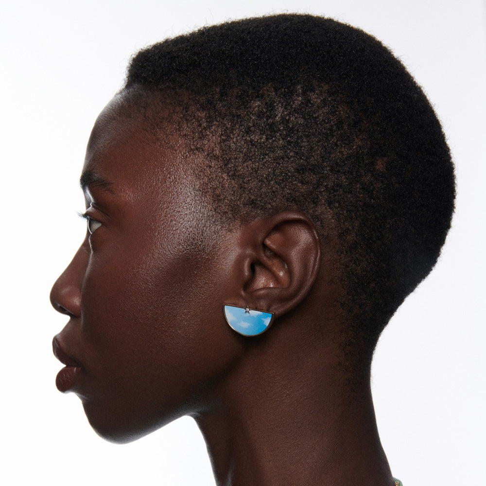 A black woman wearing Ora Half an Hour Earrings by Anna Maccieri Rossi.