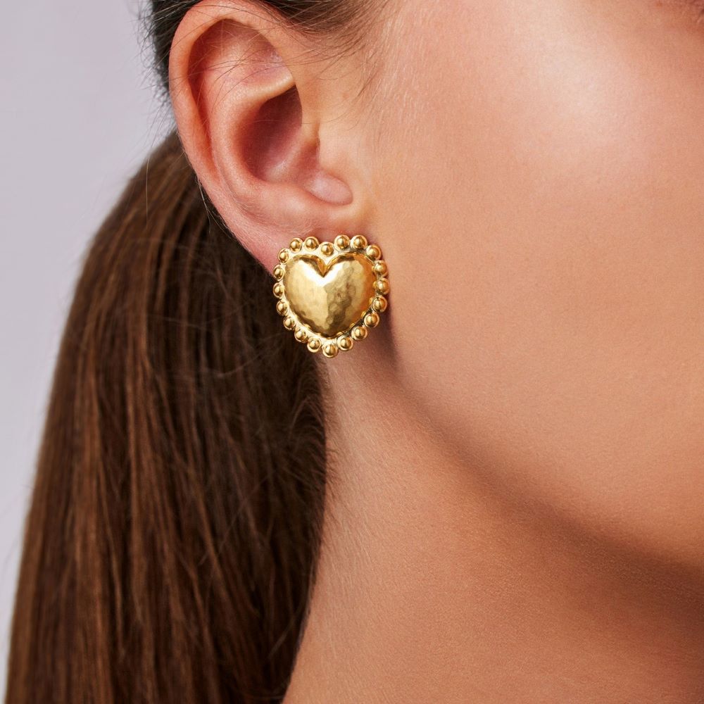 A woman wearing a Christina Alexiou Circle Heart Stud Earring.