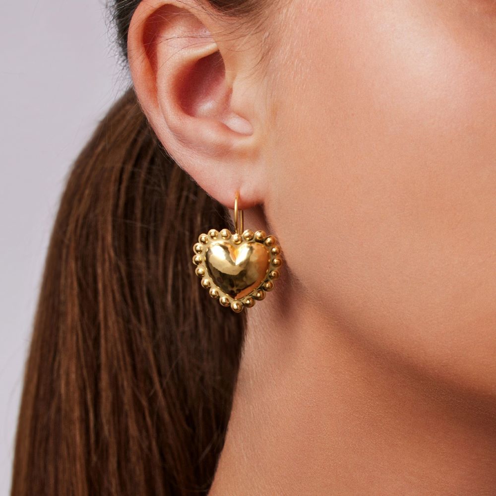 A woman donning beautiful Christina Alexiou Circle Heart Latch Earrings.