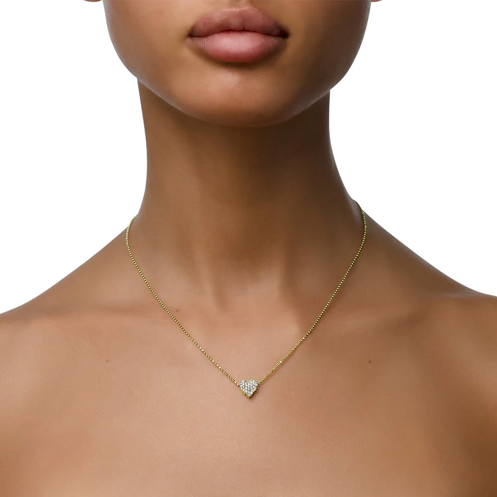 A woman wearing a Cadar Endless Heart Necklace adorned with a heart-shaped diamond.