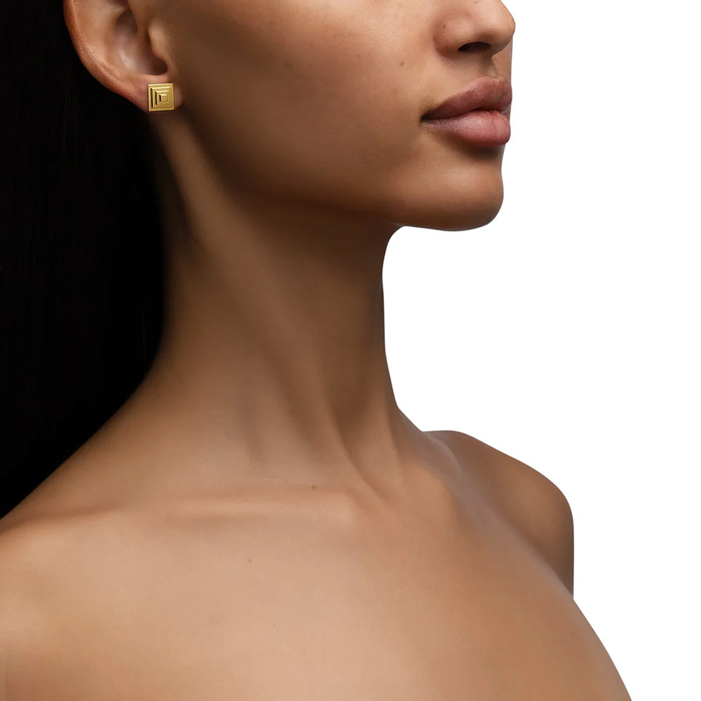 The model is wearing a pair of Cadar Foundation Pyramid Studs.