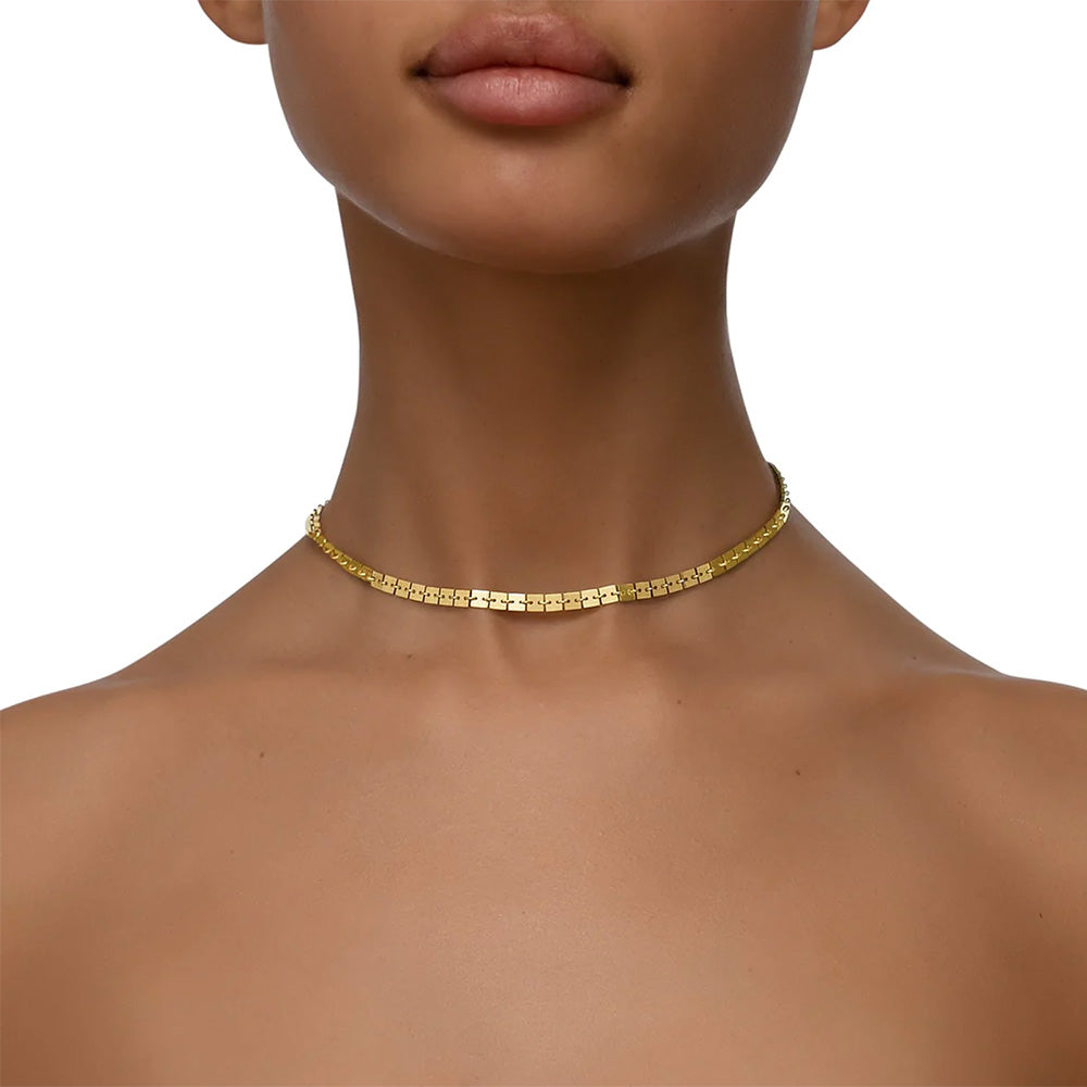 A woman wearing a Cadar Foundation Square Chain Necklace adorned with a gold choker in 18k yellow gold.