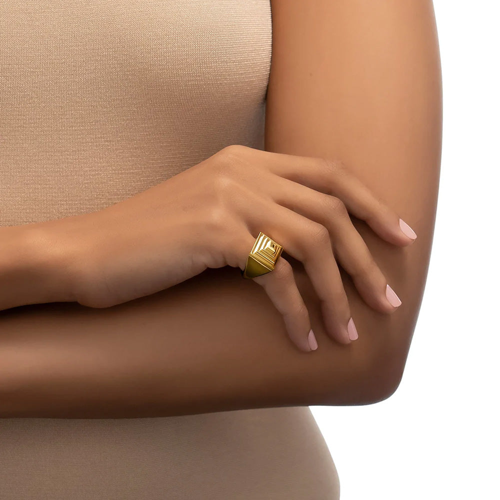 A woman wearing a Cadar Foundation Pyramid Ring on her arm.