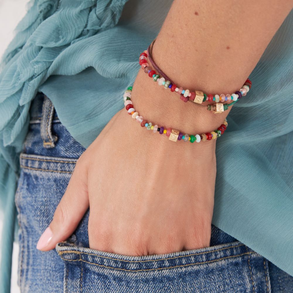 A woman's hand with a Luis Morais Multi-stone cube Bracelet in her pocket.