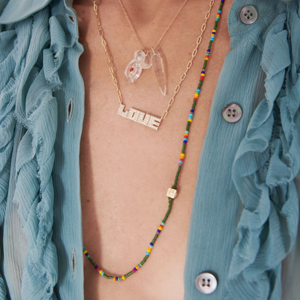 A woman wearing a blue shirt and a Luis Morais Multi-color Beaded Cube Necklace.
