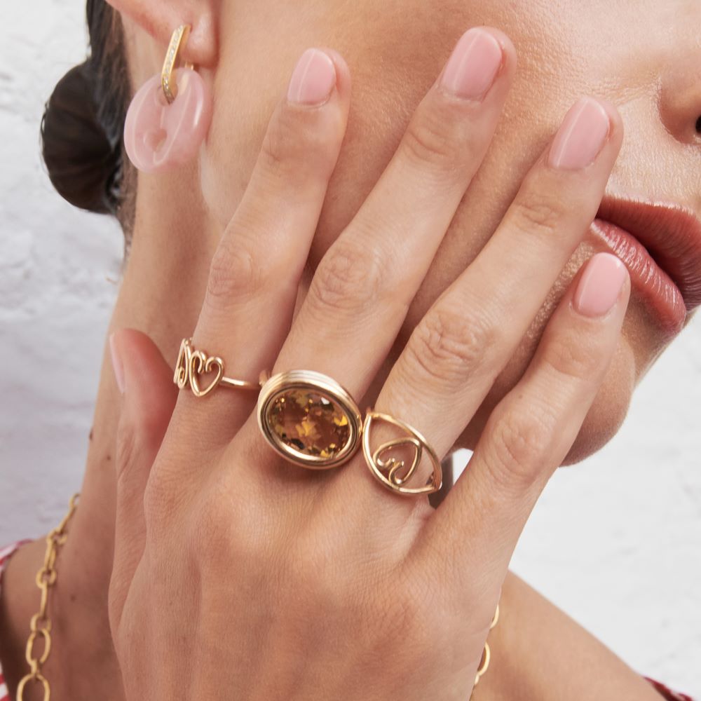 A woman wearing a Beck Scuba Ring with a yellow gold band and a citrine stone.