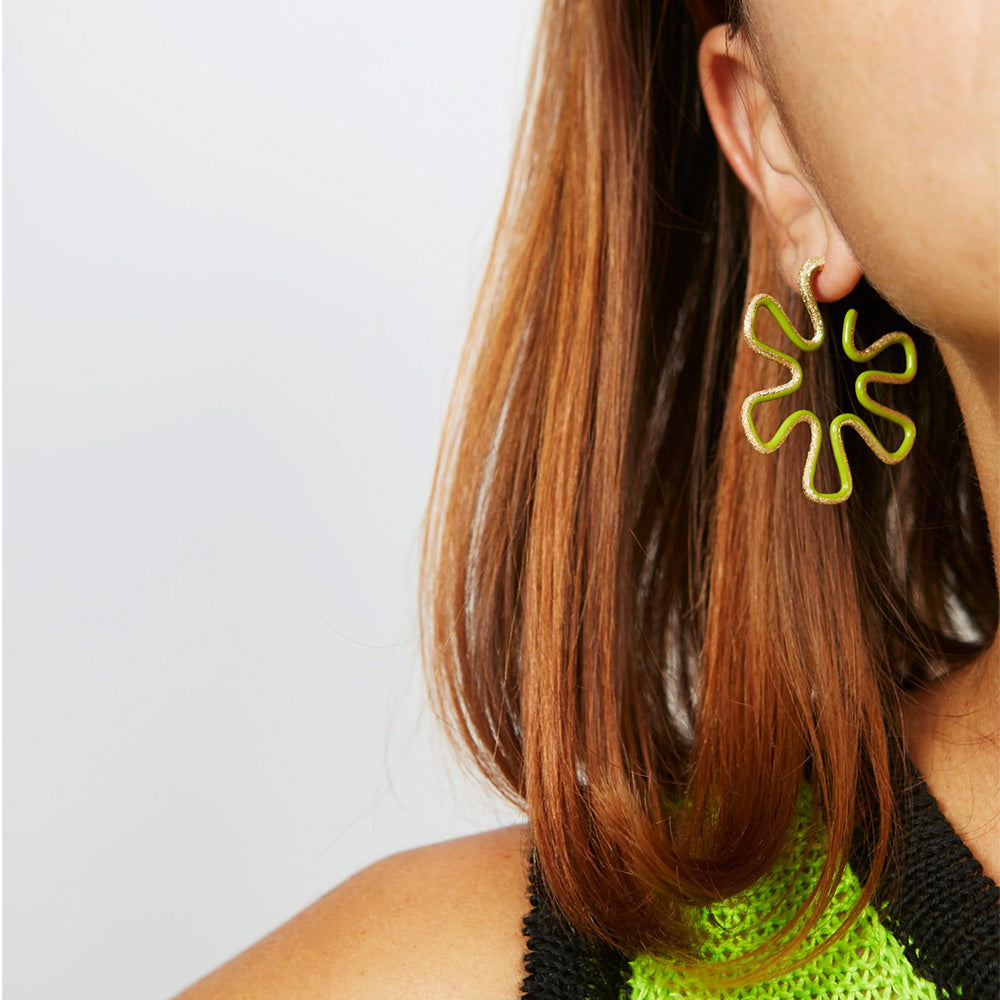 A woman is wearing a pair of Bea Bongiasca Brushed Diamond Flower Hoop Earrings with colorful enamel.