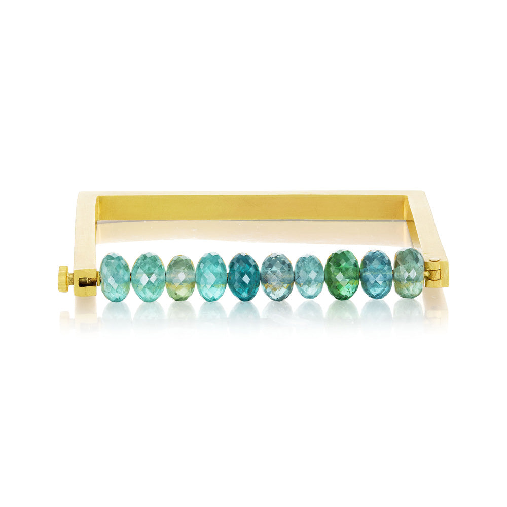A Munnu yellow gold bracelet with green and blue tourmaline beads.