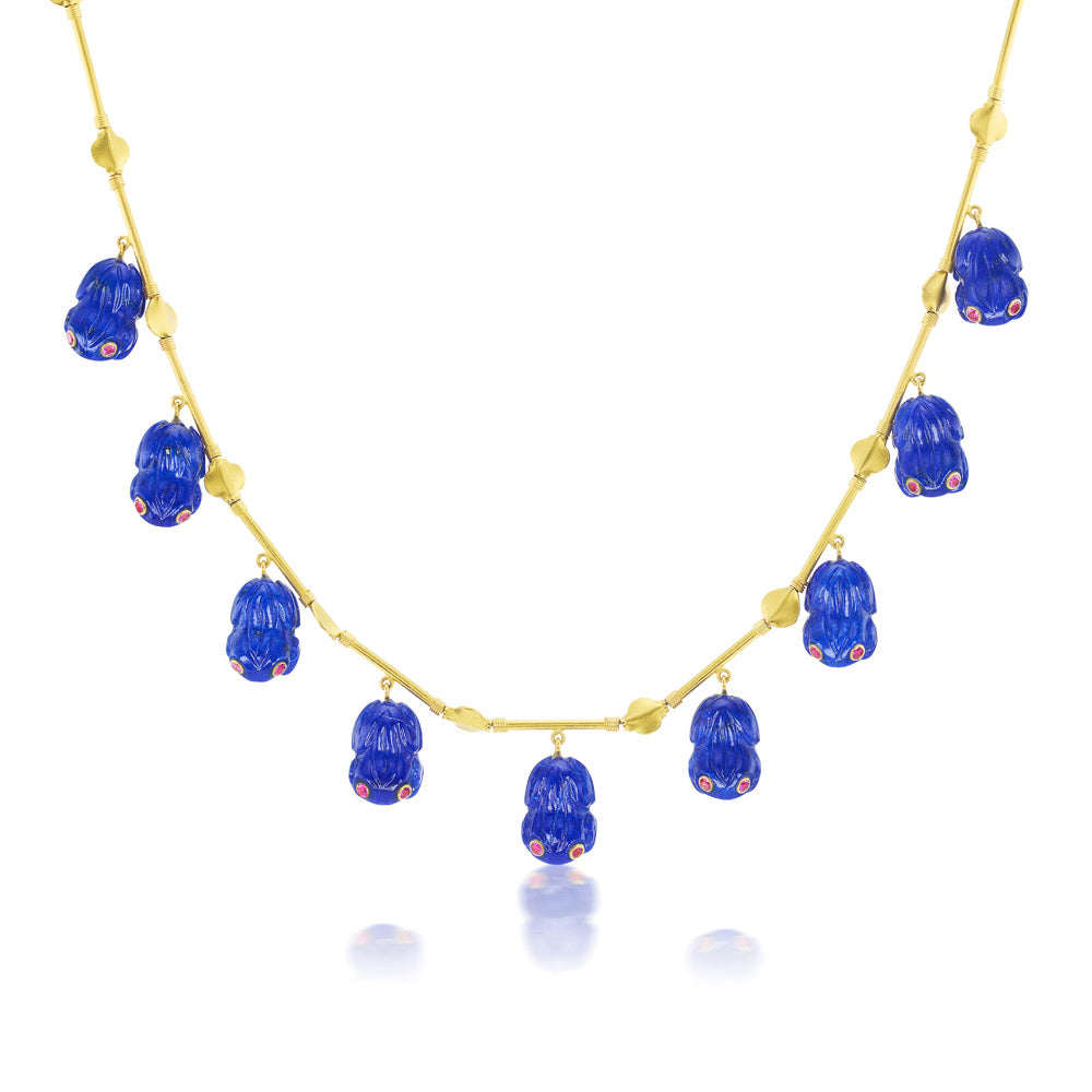 A Munnu Lapis Frog Necklace with hand-carved lapis frogs and a gold chain necklace.