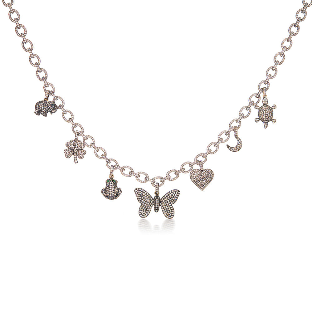 A silver necklace with a Diamond Heart Charm and other charms, including a heart charm, Munnu.
