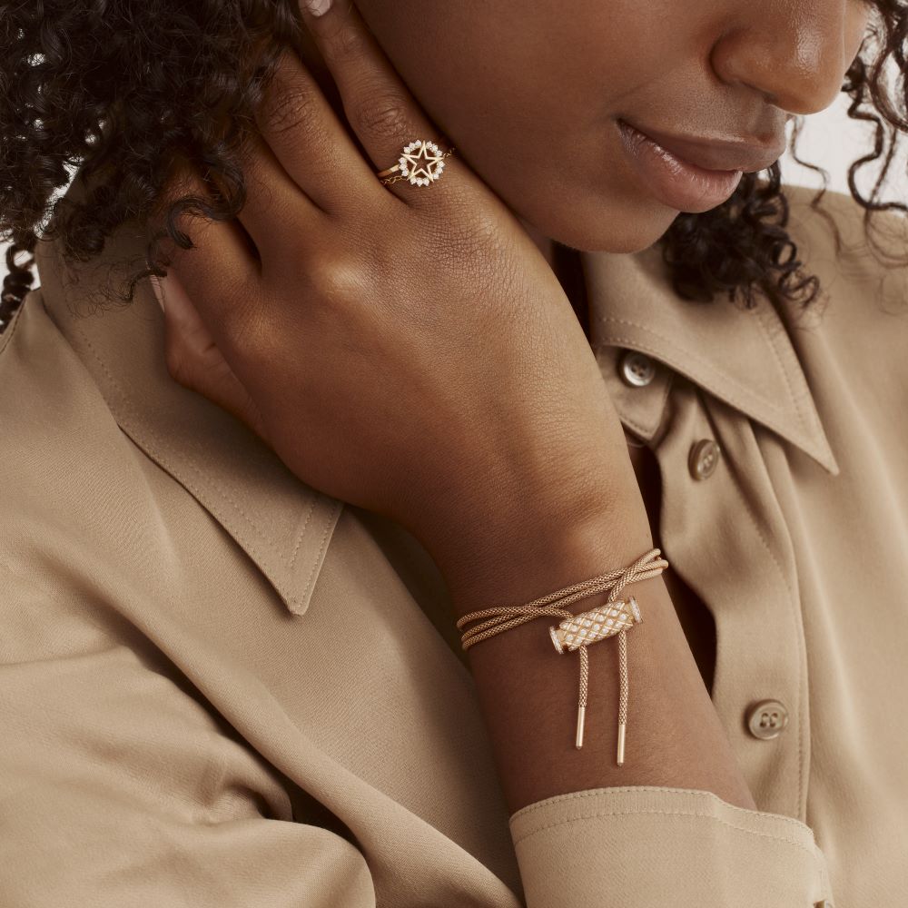 A woman wearing a tan shirt and a Nouvel Heritage Latch Chain Yellow Gold Full Diamond Necklace.