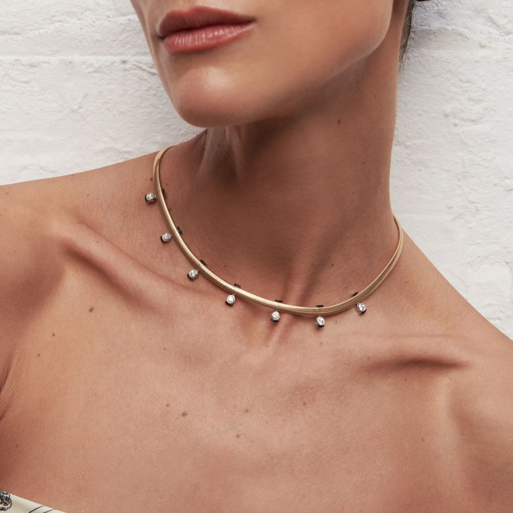 A woman wearing a Feelings Diamond Necklace by Nikos Koulis choker with white diamonds.