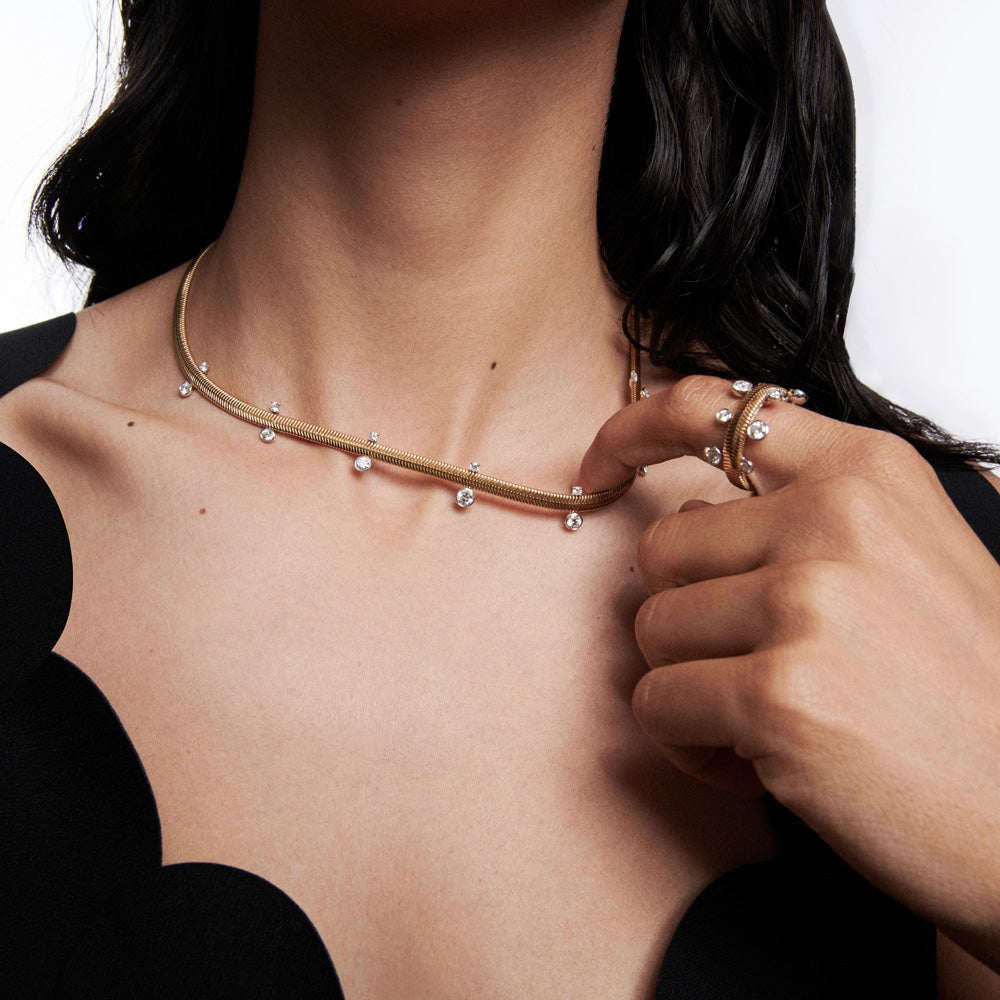 A woman wearing a Nikos Koulis Feelings Diamond Necklace and ring.