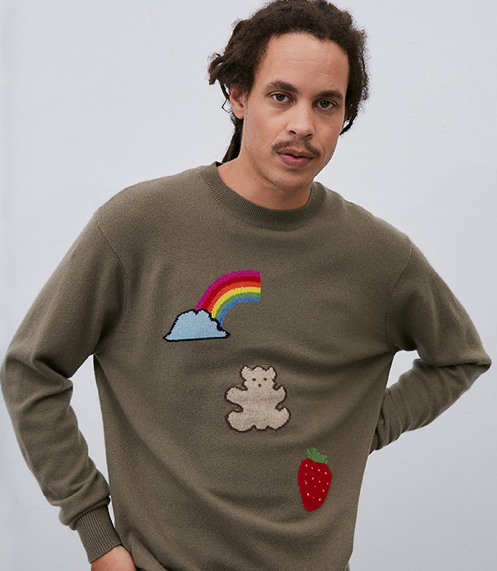 A man wearing a Leret Leret No. 52 Teddybear Sweater with a relaxed silhouette and a rainbow, bear and strawberries on it.