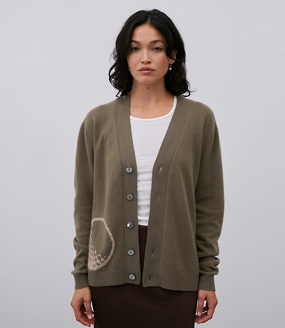 The Leret Leret model is wearing a green No. 64 Golf Cardigan with buttons.