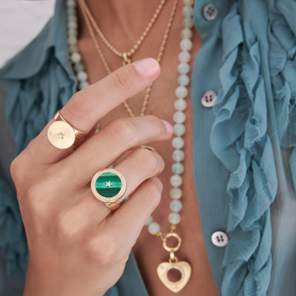 A woman wearing a gold ring with a green malachite stone featuring the Anna Maccieri Rossi Ora Pure Mini Adjustable Ring