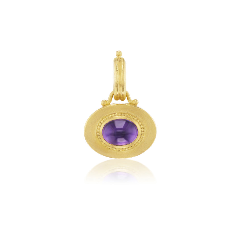 The Granulated Heart Charm pendant by Prounis showcases a vibrant purple stone.