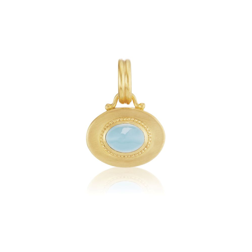 A yellow gold Prounis Granulated Heart Charm pendant set with a blue topaz cabochon center stone.