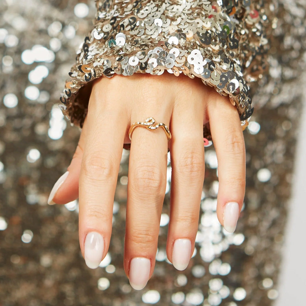 A woman donning a sequin dress and shimmering with a Bea Bongiasca Wave Ring.